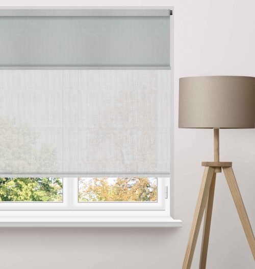 Motorised roller blinds fitted across large high windows in a contemporary living room