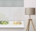 Motorised roller blinds fitted across large high windows in a contemporary living room
